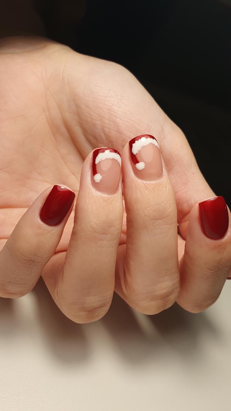 Czerwony manicure z bialym akcentem na nasadzie paznokcia