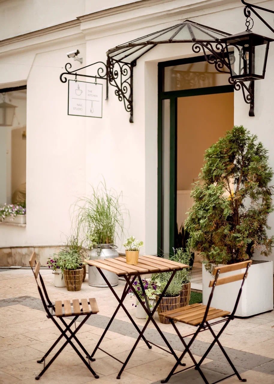 Bistro stolik i krzesla przed wejsciem do studia w ciagu dnia