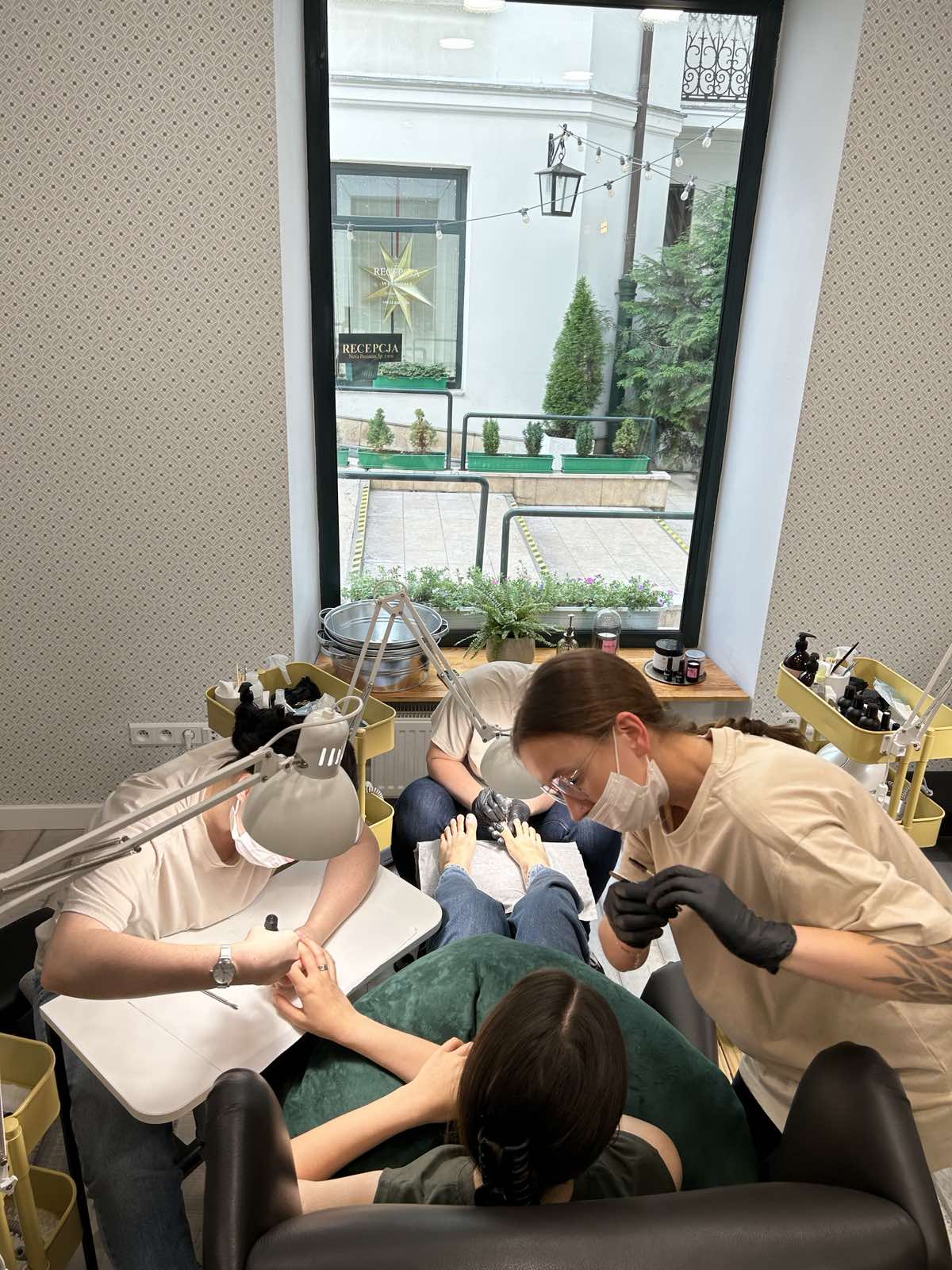 Stanowisko manicure przy oknie z widokiem na zielen